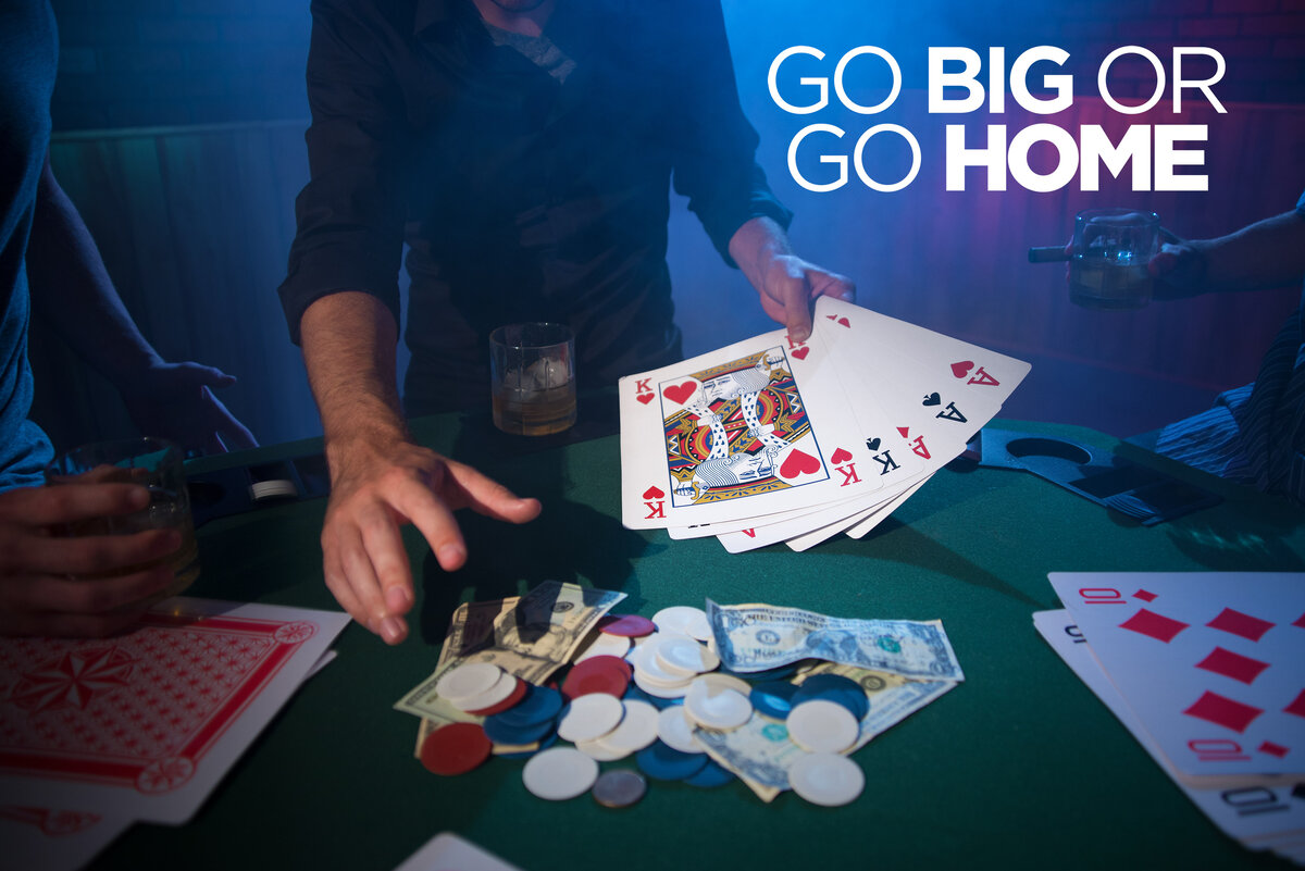 Men playing poker with gigantic playing cards.