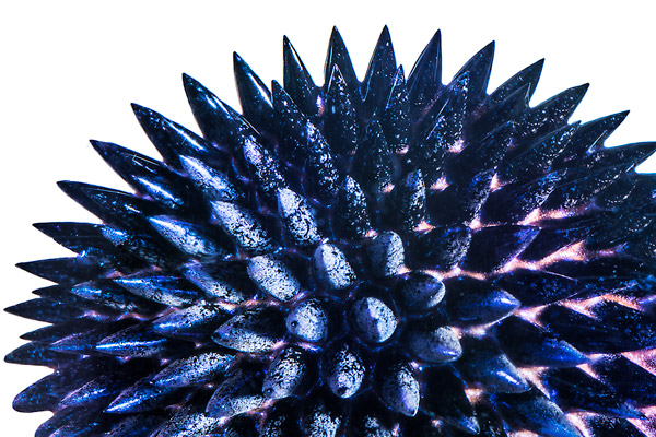 Extreme close-up of blue ferrofluid spiking in the presence of a magnetic field.