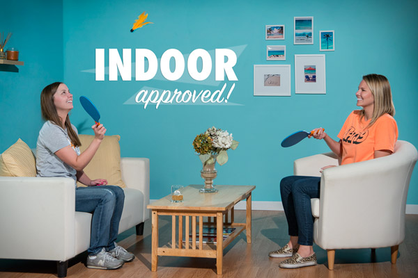 Two women playing Goodminton indoors.